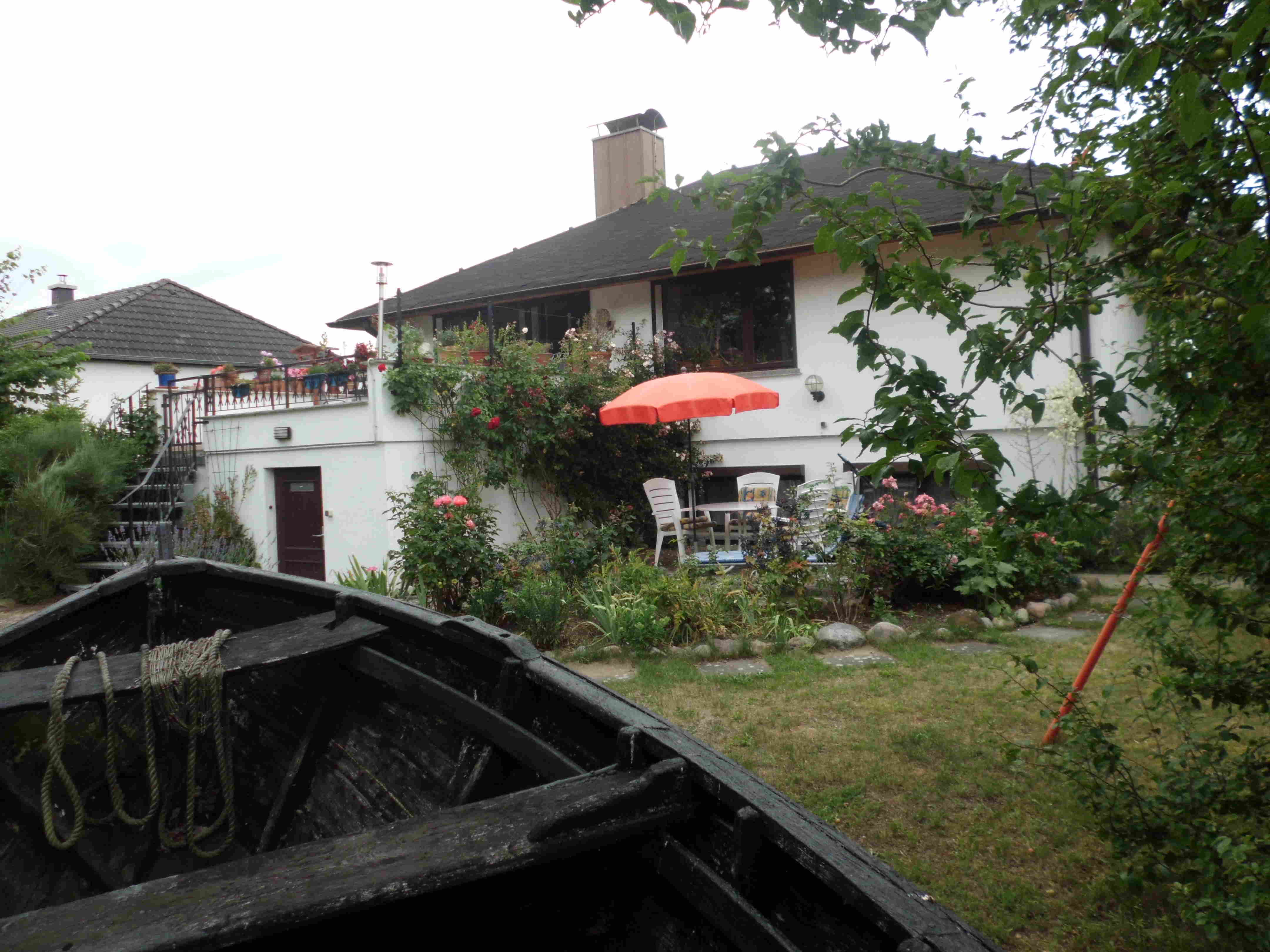 Haus Sedina mit Terrasse und Garten zum Erholen. Im Vordergrund ein altes Fischerboot, rechts die Schaukel für die Kinder.