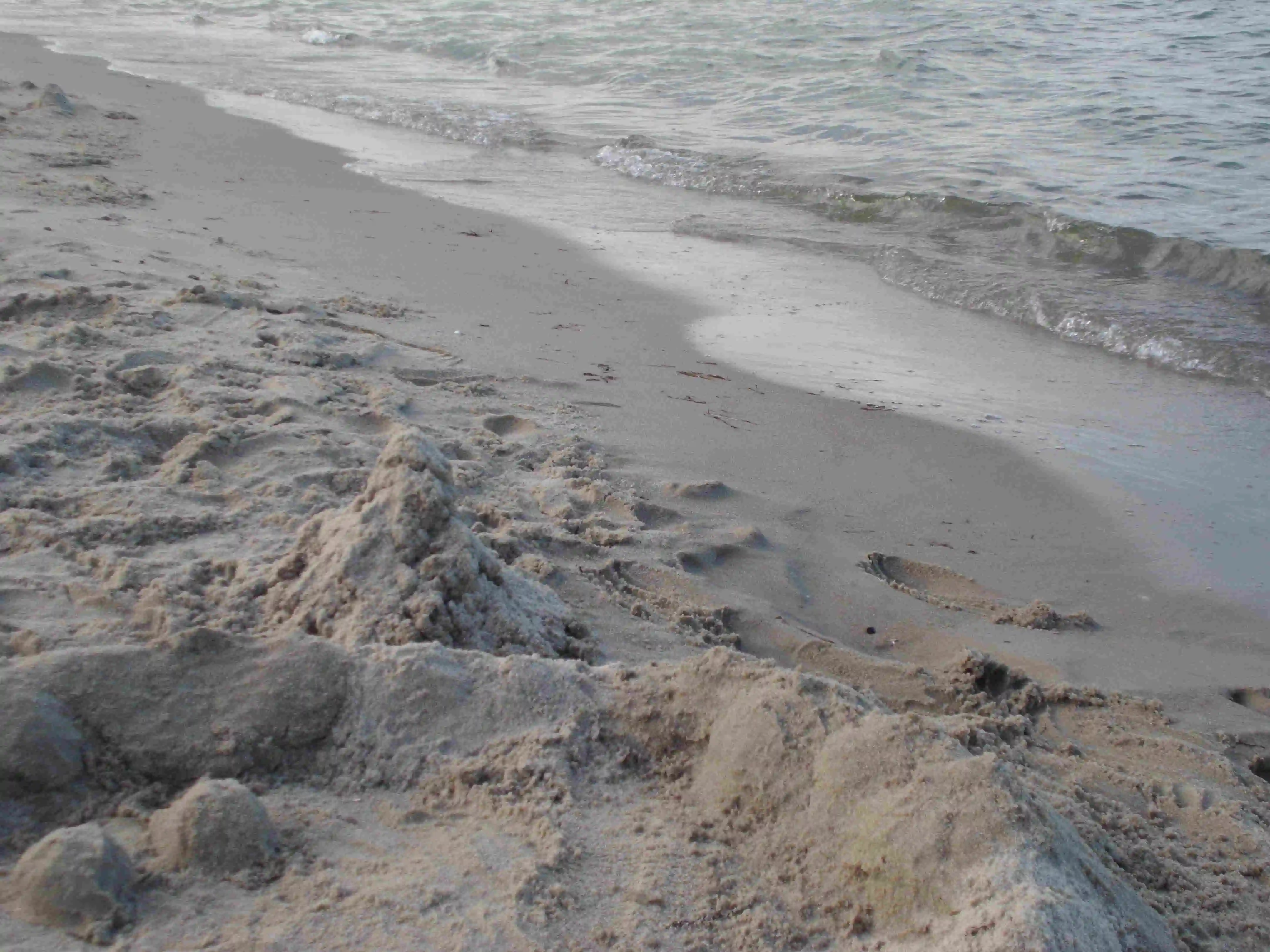 Der abendliche Sandstrand mit einem kleinen Sandhafen, ein schöner Spielplatz für die Kinder.