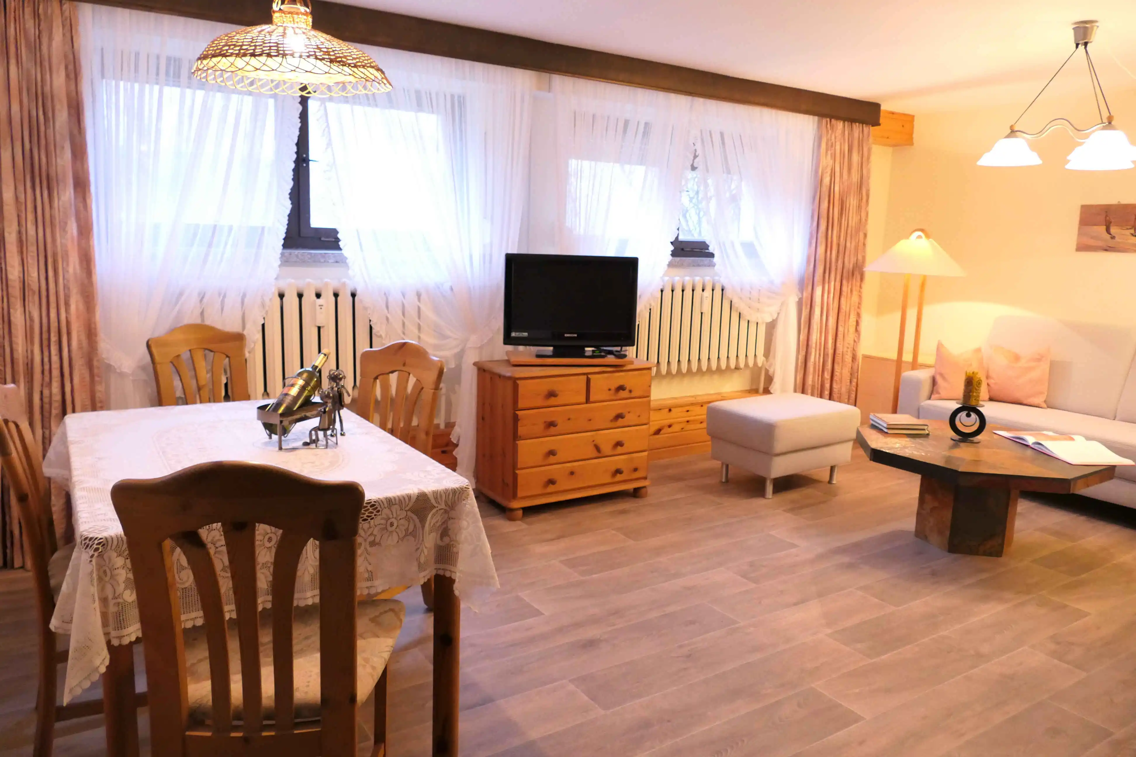 Das sonnendurchflutete Wohnzimmer mit seiner Essecke und dem Fernseher.